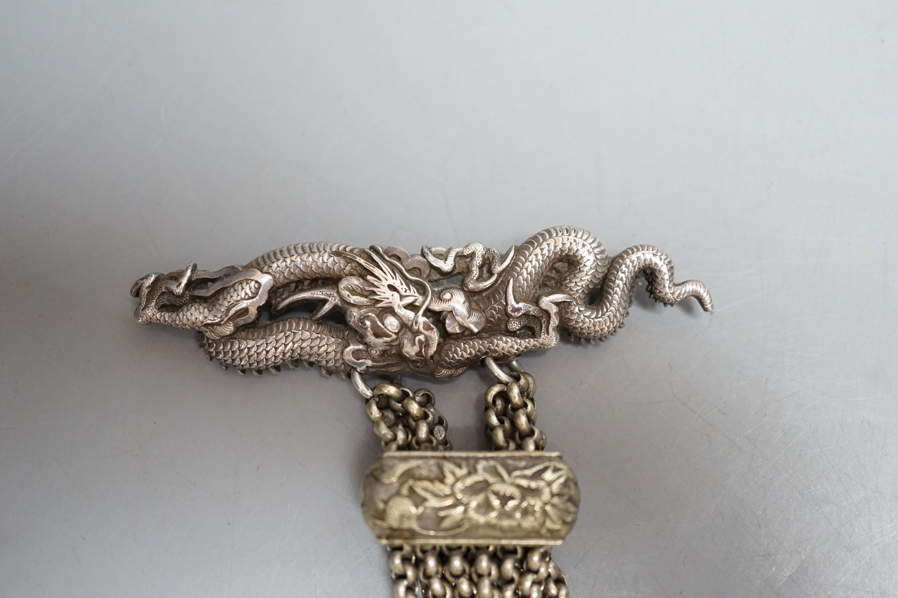 A Japanese ivory Manju netsuke with white metal and base metal suspension brooch
